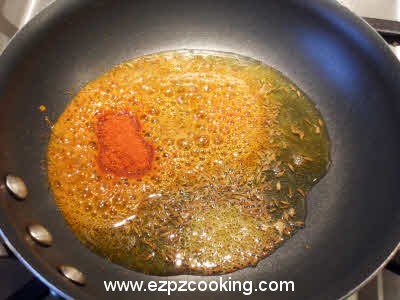 Add chili powder and asafoetida to the dhuli masoor dal tempering