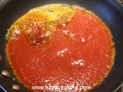 Add tomato puree and green chilies to the dal tempering