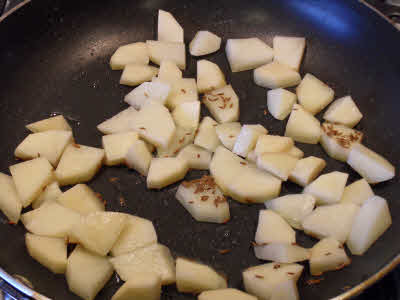 Oil + cumin seeds + potatoes