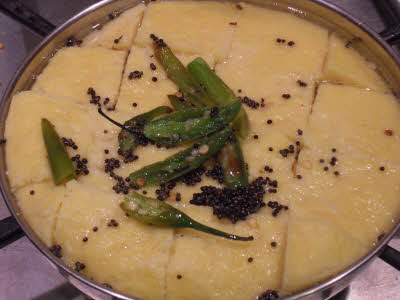 Pour the tempering on Dhokla