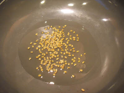 Heat oil in a wok and add methi seeds