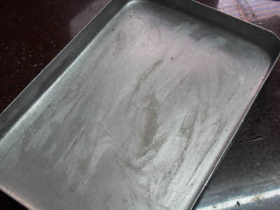 Grease a tray for til ki burfi batter