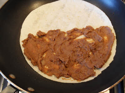 Spread beans on tortilla for quesadilla