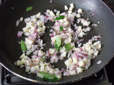 Frying onion and potatoes for Upma