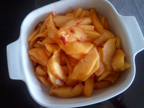 Peel and slice peaches finely