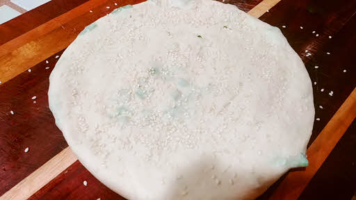 Sprinkle sesame seeds on dough
