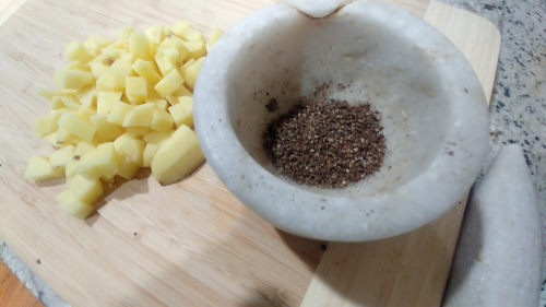 Add crushed black pepper, crushed cloves, and crushed cardamom
